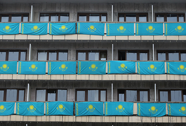 Kazakh state flags hang out from balconies of a building on Independence Day in Almaty, Kazakhstan December 16, 2020. REUTERS/Pavel Mikheyev